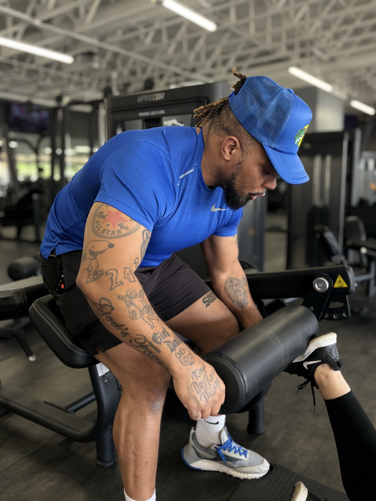 Justin coaching form on a leg curl machine — close-up arms and posture